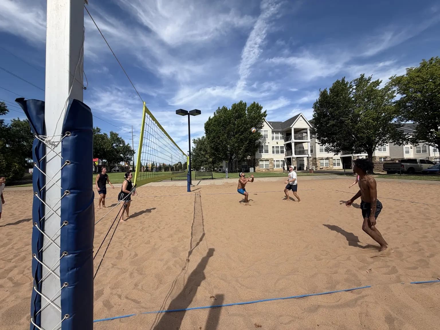 Players settle under a high ball beside the net during the August 15 pickup