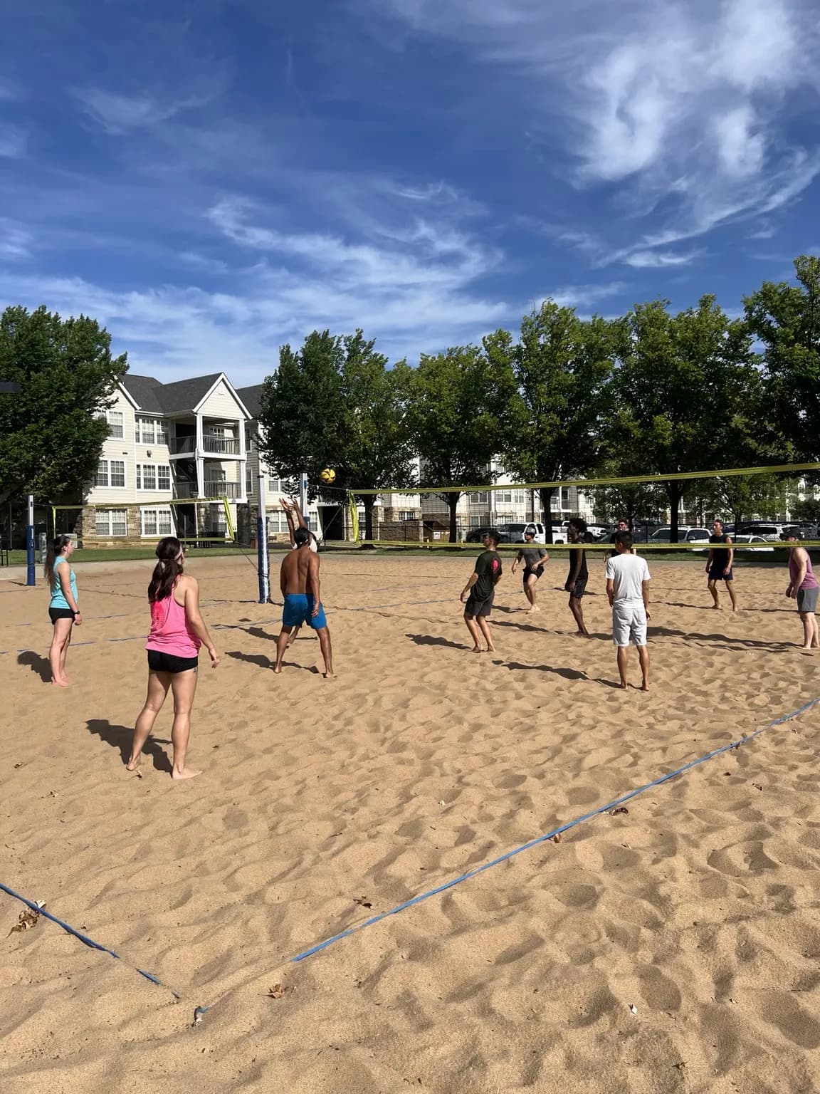 Sandline players cover the full court as the ball travels above the net