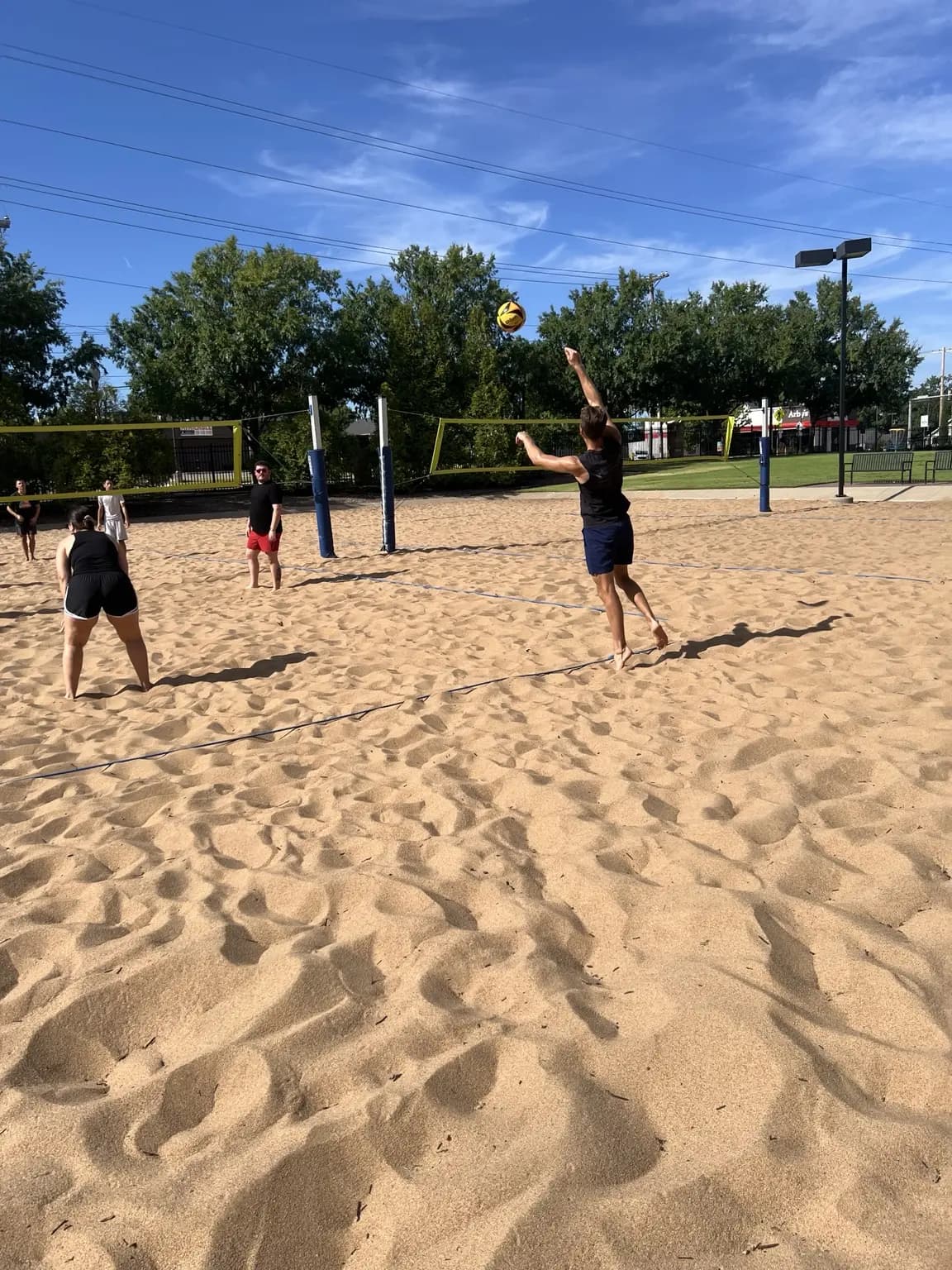 A Sandline player jumps from the back court to send the ball toward the net