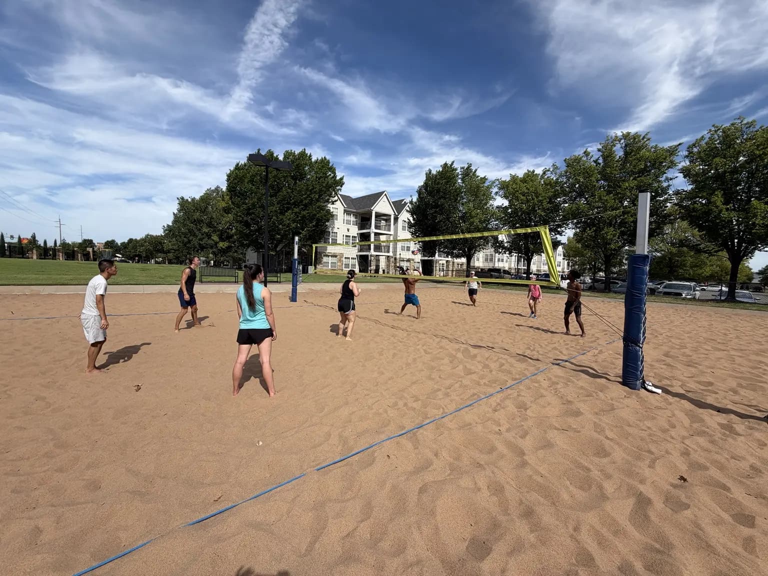 A wide view of an August 15 net attack with both teams closing toward the ball