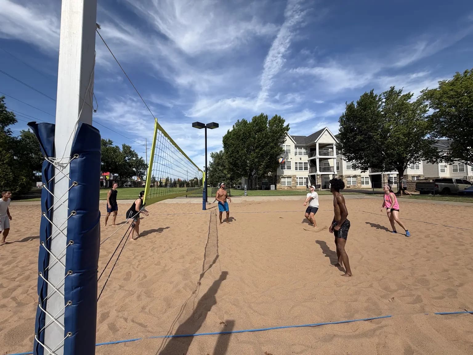 A Sandline player prepares to receive while teammates track the ball across the net