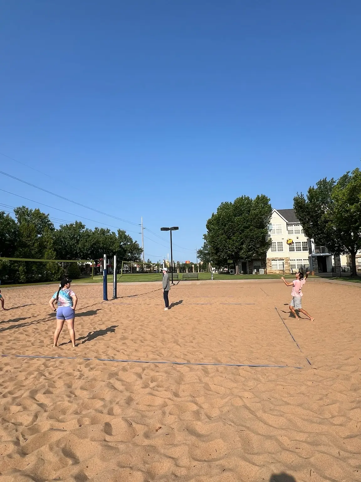 A wide courtside view of Sandline players spread across the sand