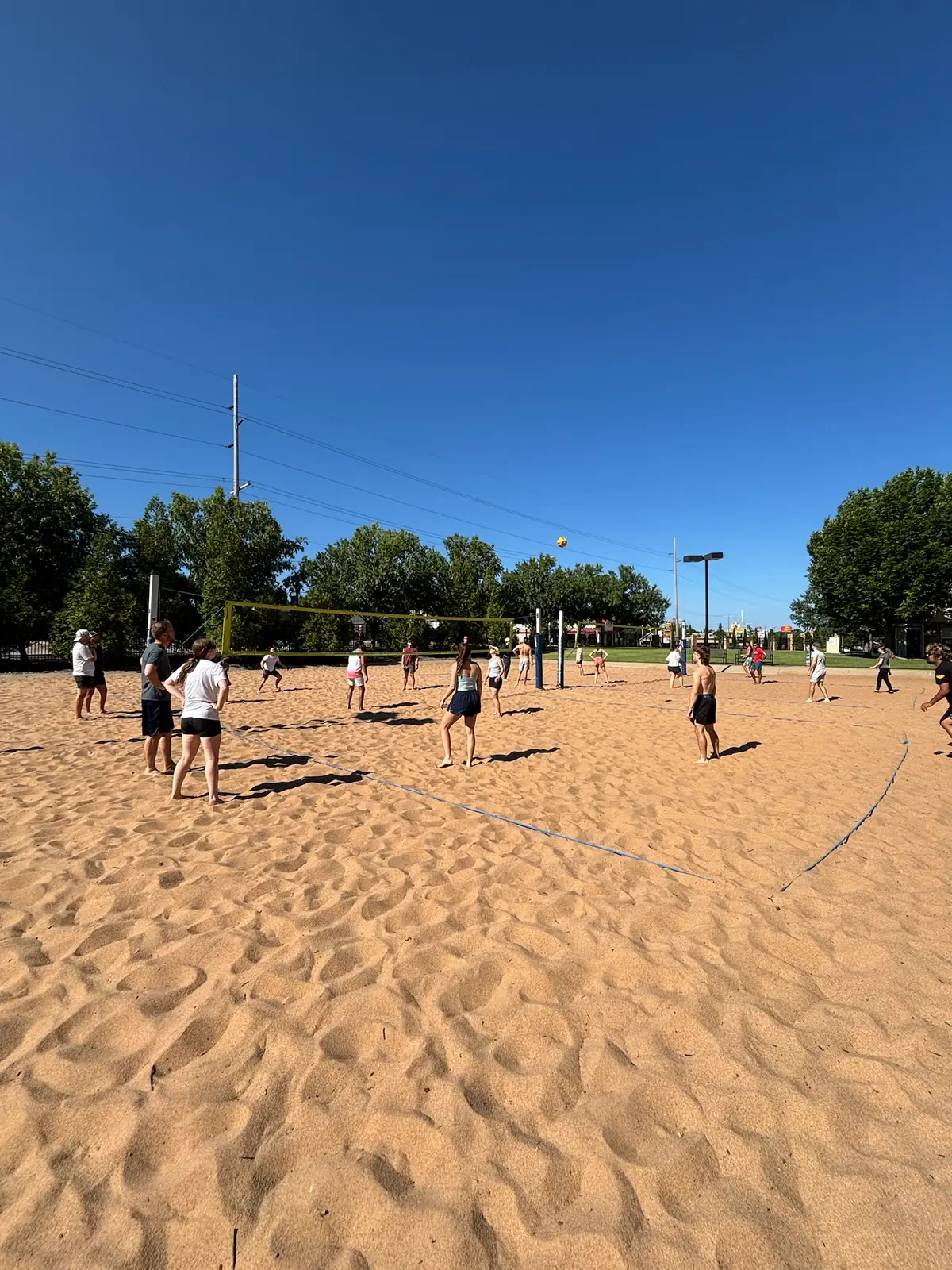 A wide view of multiple Sandline games running across the TU sand courts