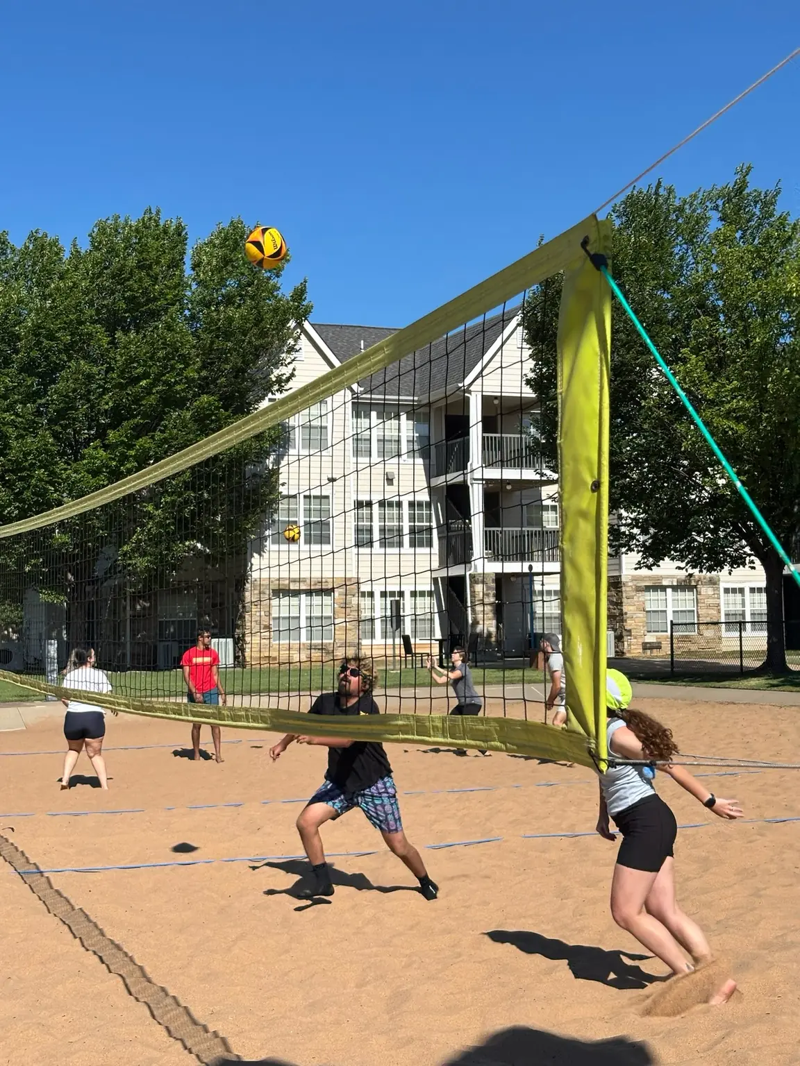 Two Sandline teams tracking a ball above the net during an August pickup