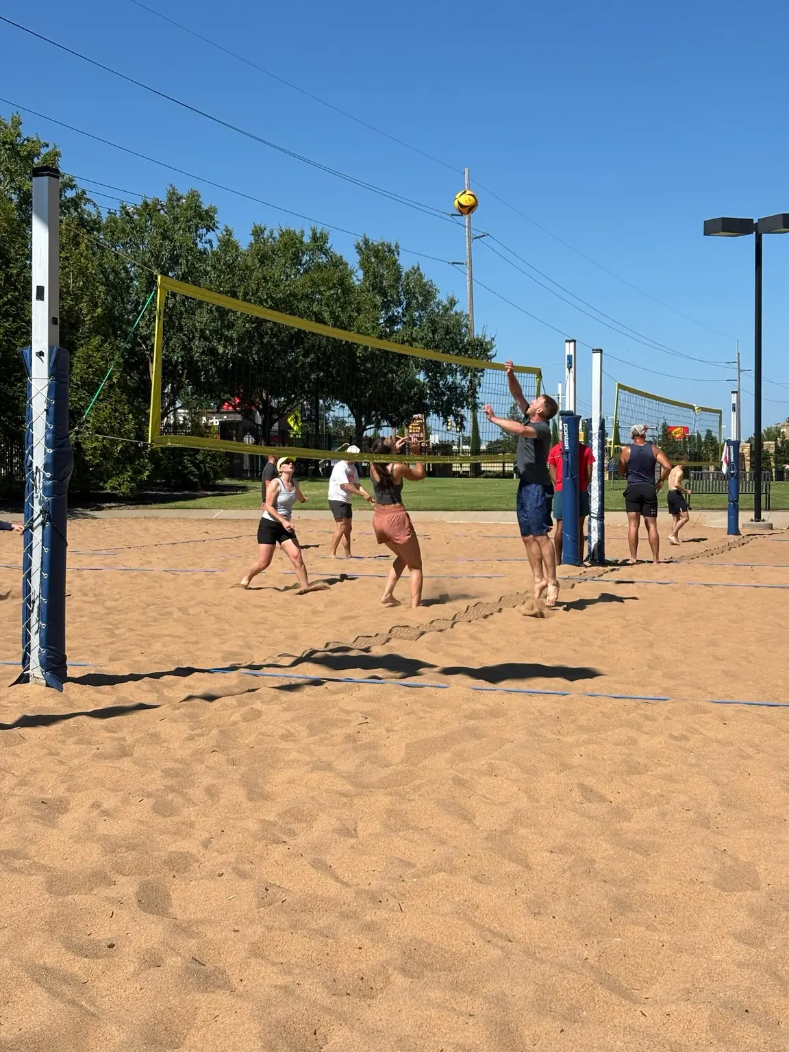 A close Sandline rally unfolding near the net at TU Sand Courts