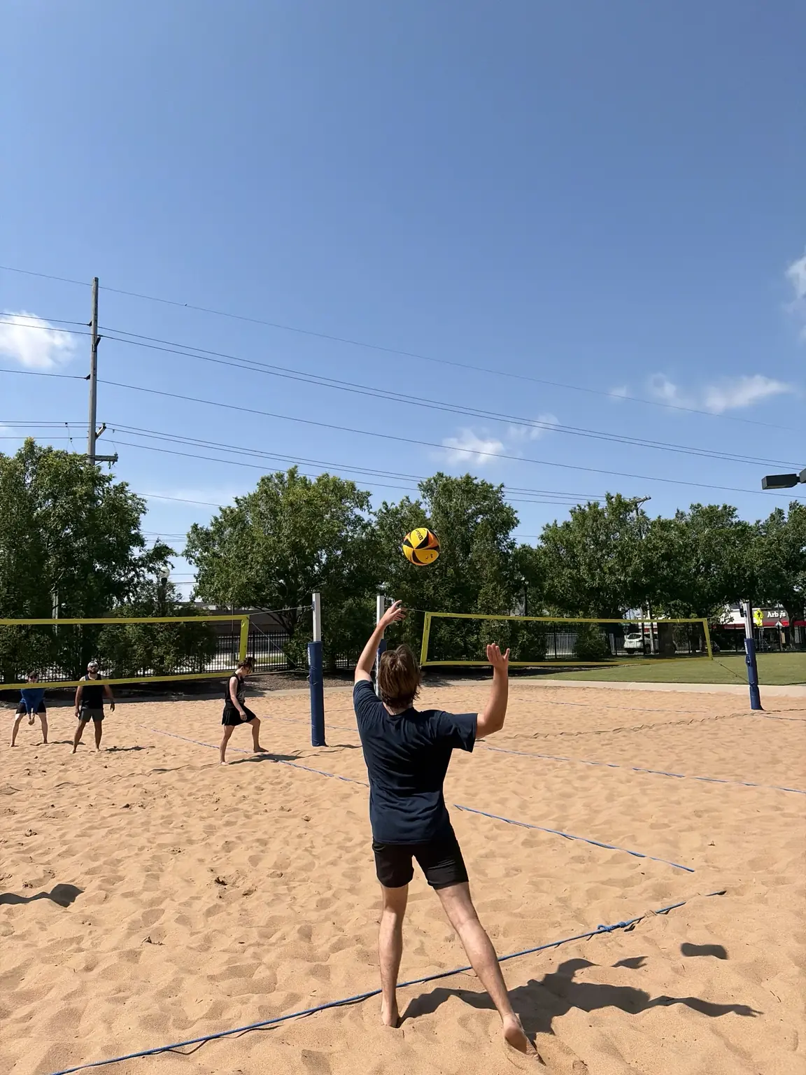 A Sandline player setting the ball from the back of the court