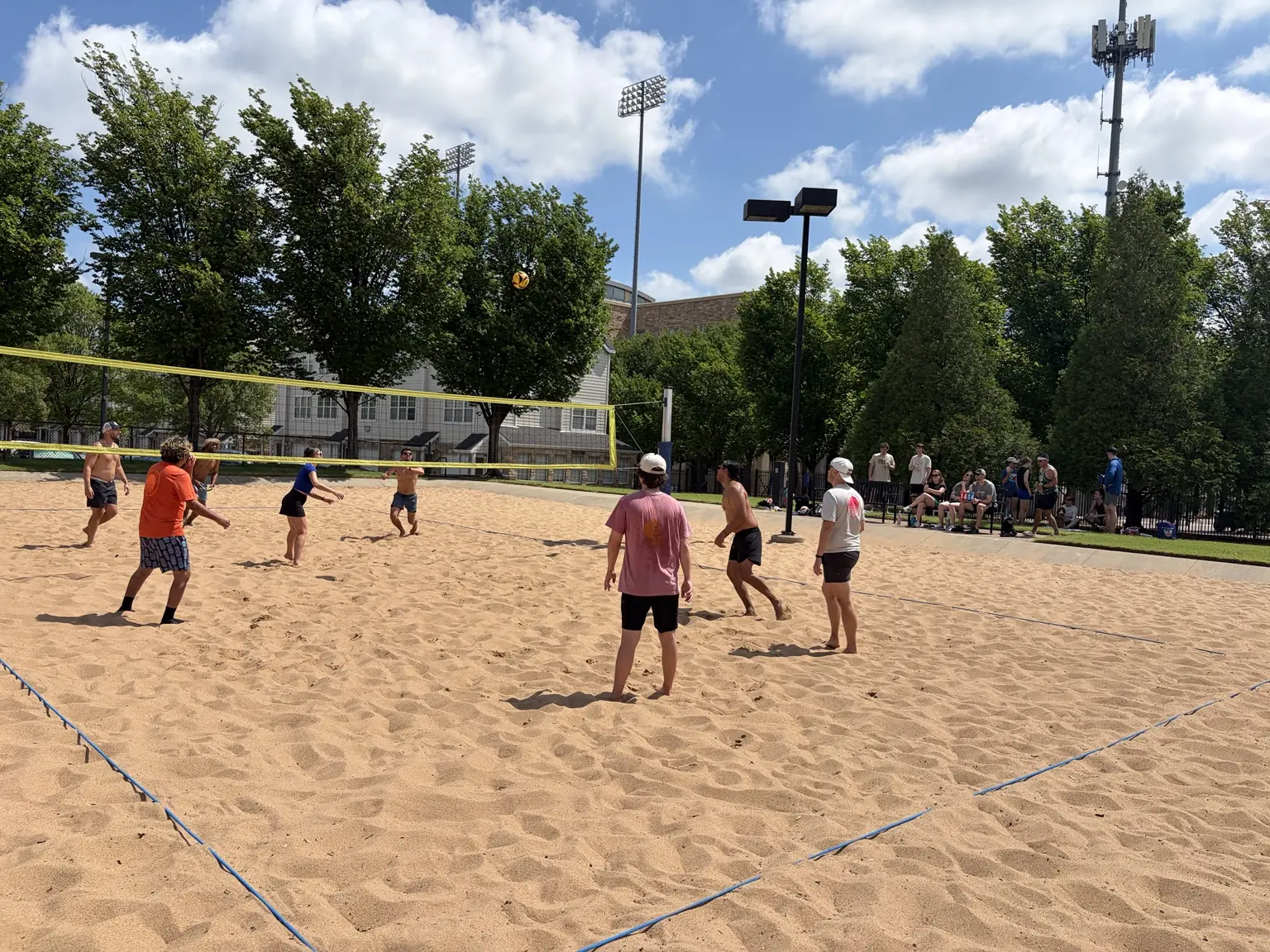 A wide summer view of a Sandline pickup with players and spectators